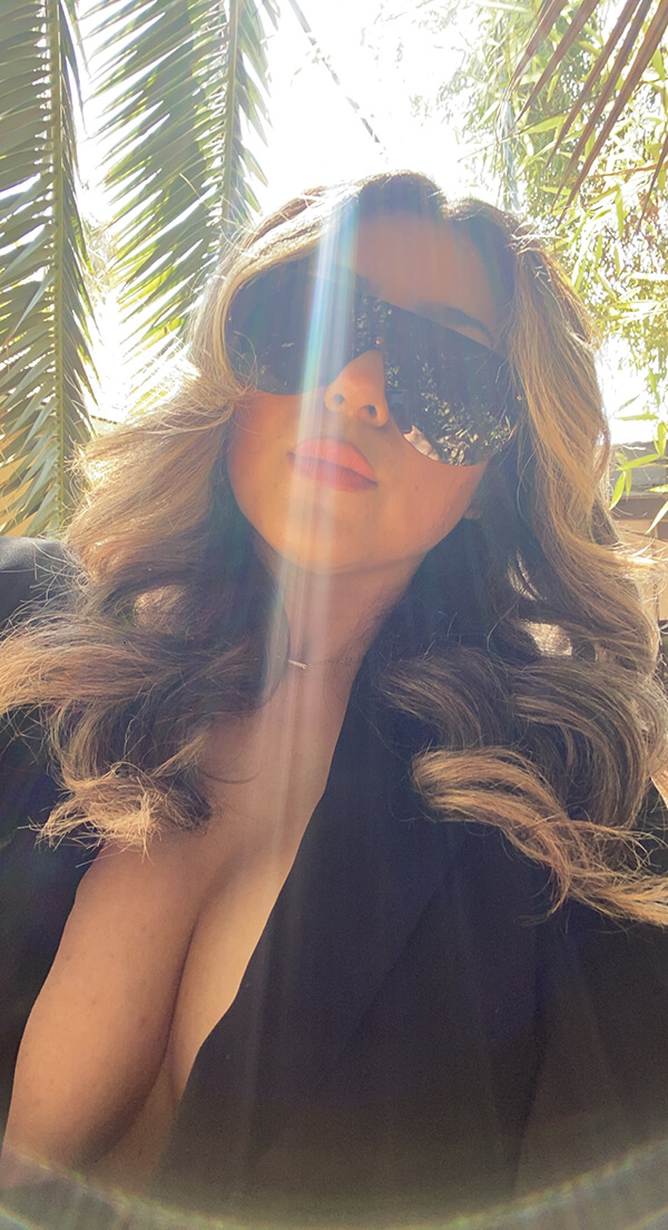 Woman with styled hair wearing a glamorous black sunglasses.