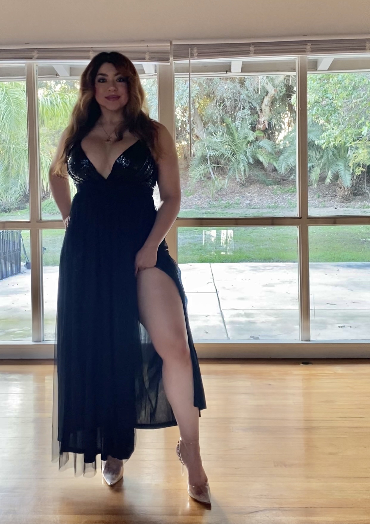 Confident woman posing elegantly in a glamorous evening gown.