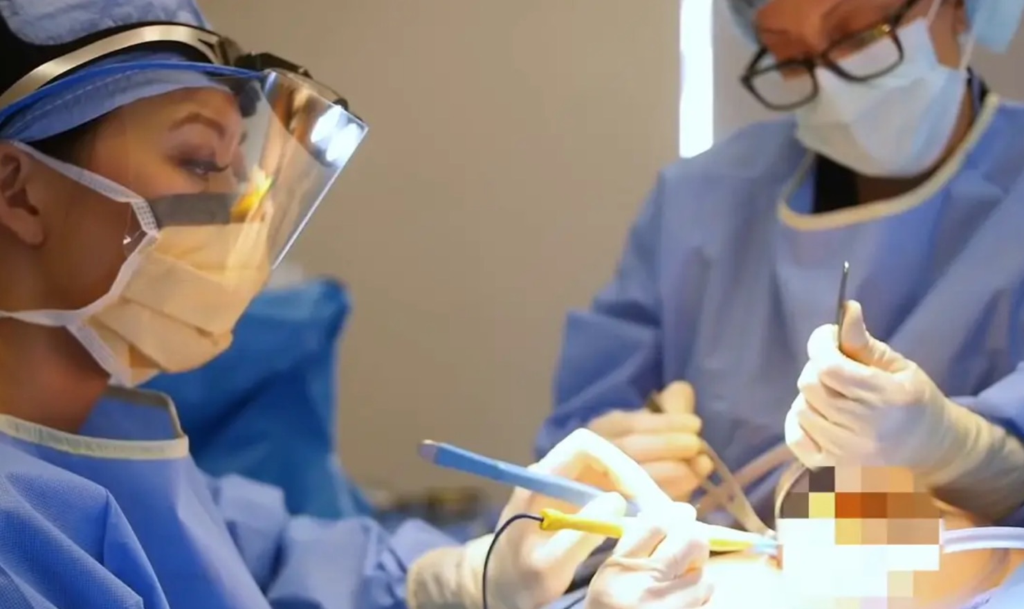 Dr. Cat performing precise breast augmentation surgery in an operating room setting.