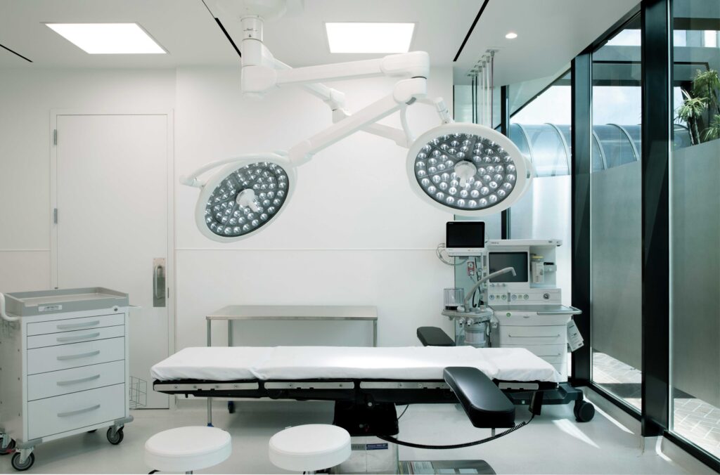 Operating room with surgical lights, operating table and anesthesia station in the QUAD A accredited surgery center