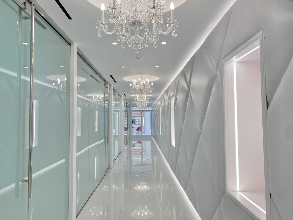 Crystal chandelier over the corridor, with glass doors to the exam rooms