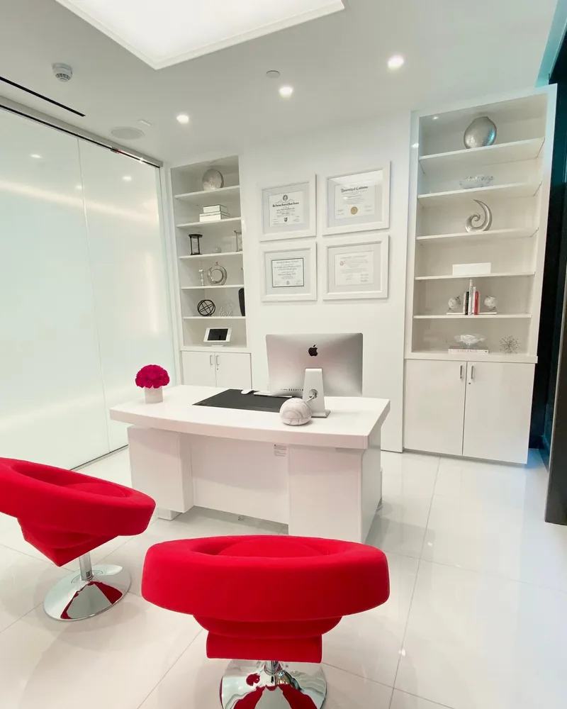 Consultation room at Dr. Cat Plastic Surgery with built-in shelves and framed diplomas